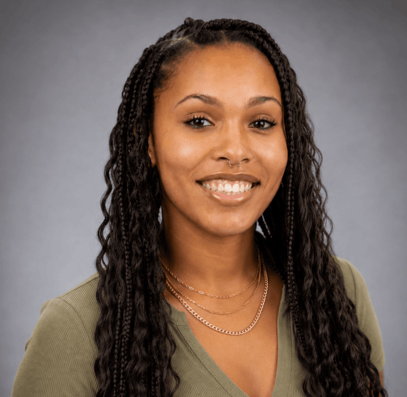 Shyan Cleveland smiling wearing green shirt with gray background